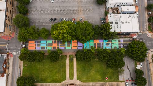 Free Aerial view of roadway with bright Black Lives Matter inscription near lawn with trees and parking in city Stock Photo