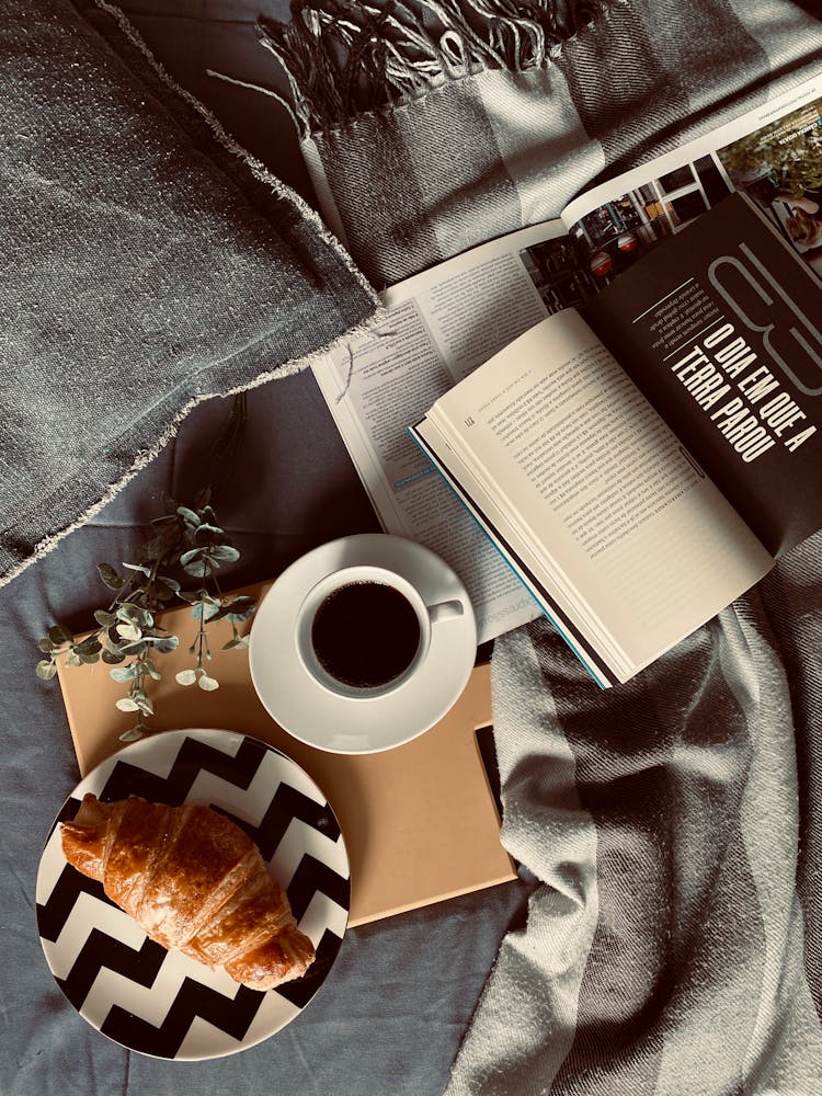 An Coffee And A Croissant Beside An Open Book