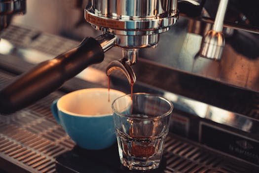 Espresso dripping into a glass cup from a metallic machine, capturing coffee essence.