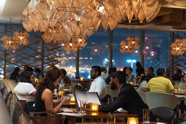 A Couple Looking At A Menu While Sitting At A Restaurant