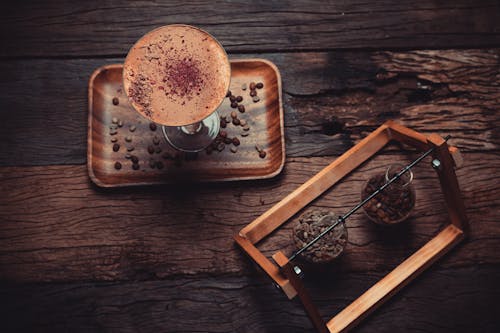 Coffee Beans on Board and in Glass Jars on Wooden Table