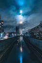 夜晚，东京天空树在雾气笼罩的城市景观中闪闪发光，倒映在一条反光的运河上