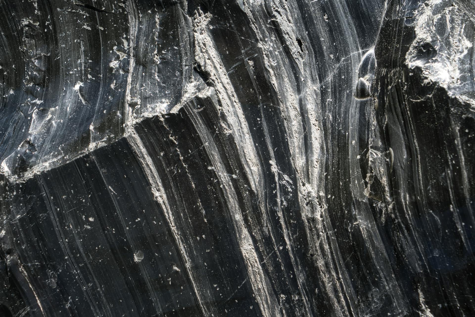 Detailed close-up of black obsidian rock showcasing rough texture and natural patterns.