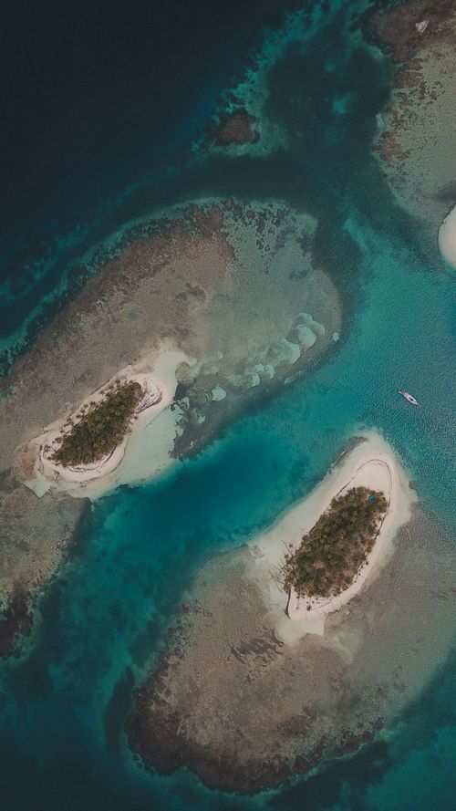 Free Explore the stunning aerial view of secluded tropical islands in Panama's Guna Yala, showcasing vibrant coral reefs. Stock Photo