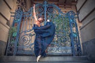 在圣保罗的装饰大门前，一位优雅的芭蕾舞演员穿着蓝色连衣裙翩翩起舞