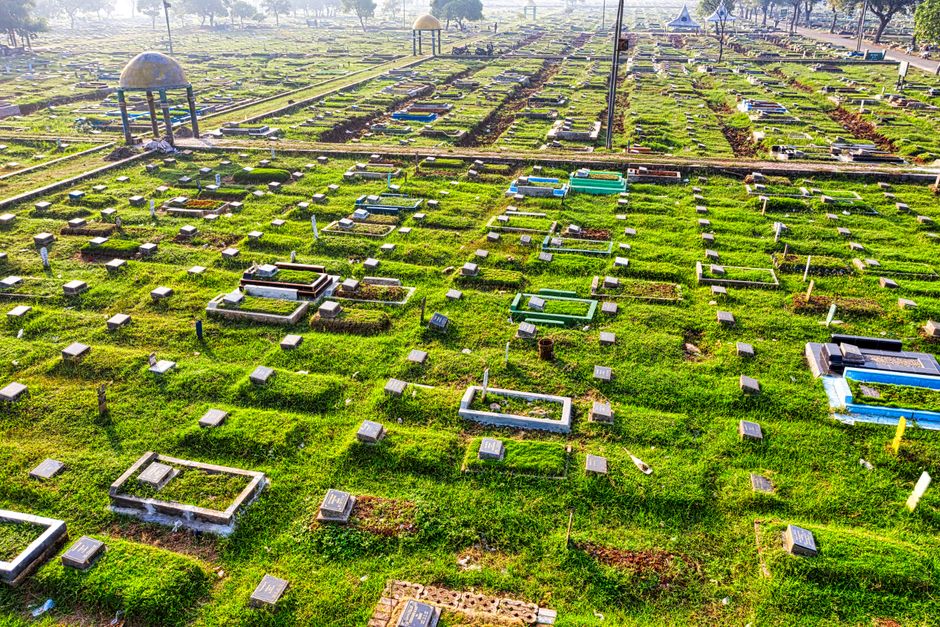 Aerial view of a lush cemetery in Jakarta, Indonesia, with numerous gravestones.