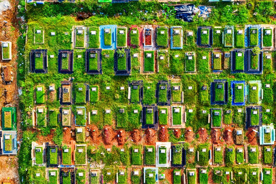 Aerial shot of a cemetery in Jakarta, showcasing colorful gravestones and lush greenery.