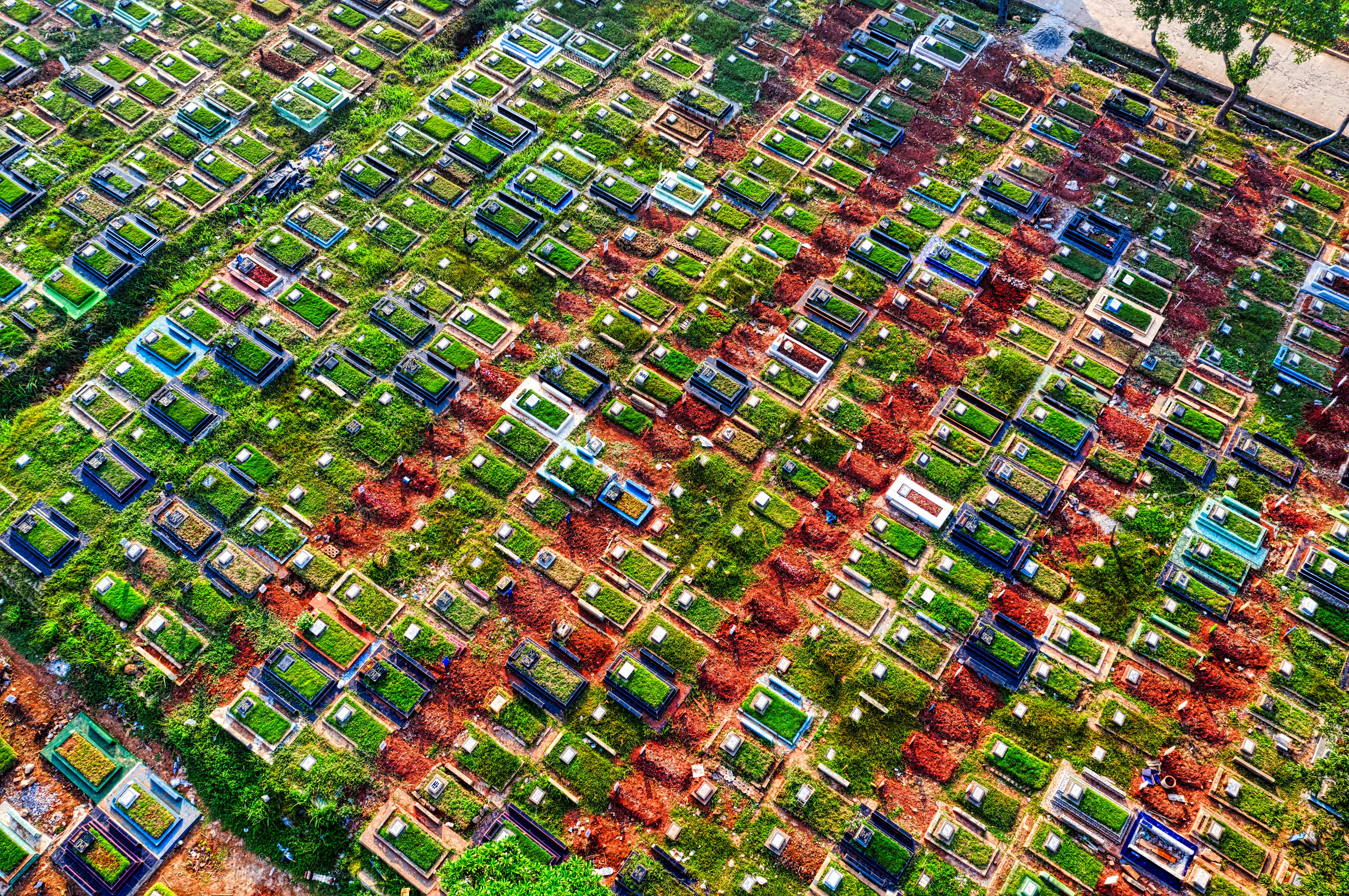 Aerial view of lush cemetery with colorful graves in Jakarta, Indonesia.