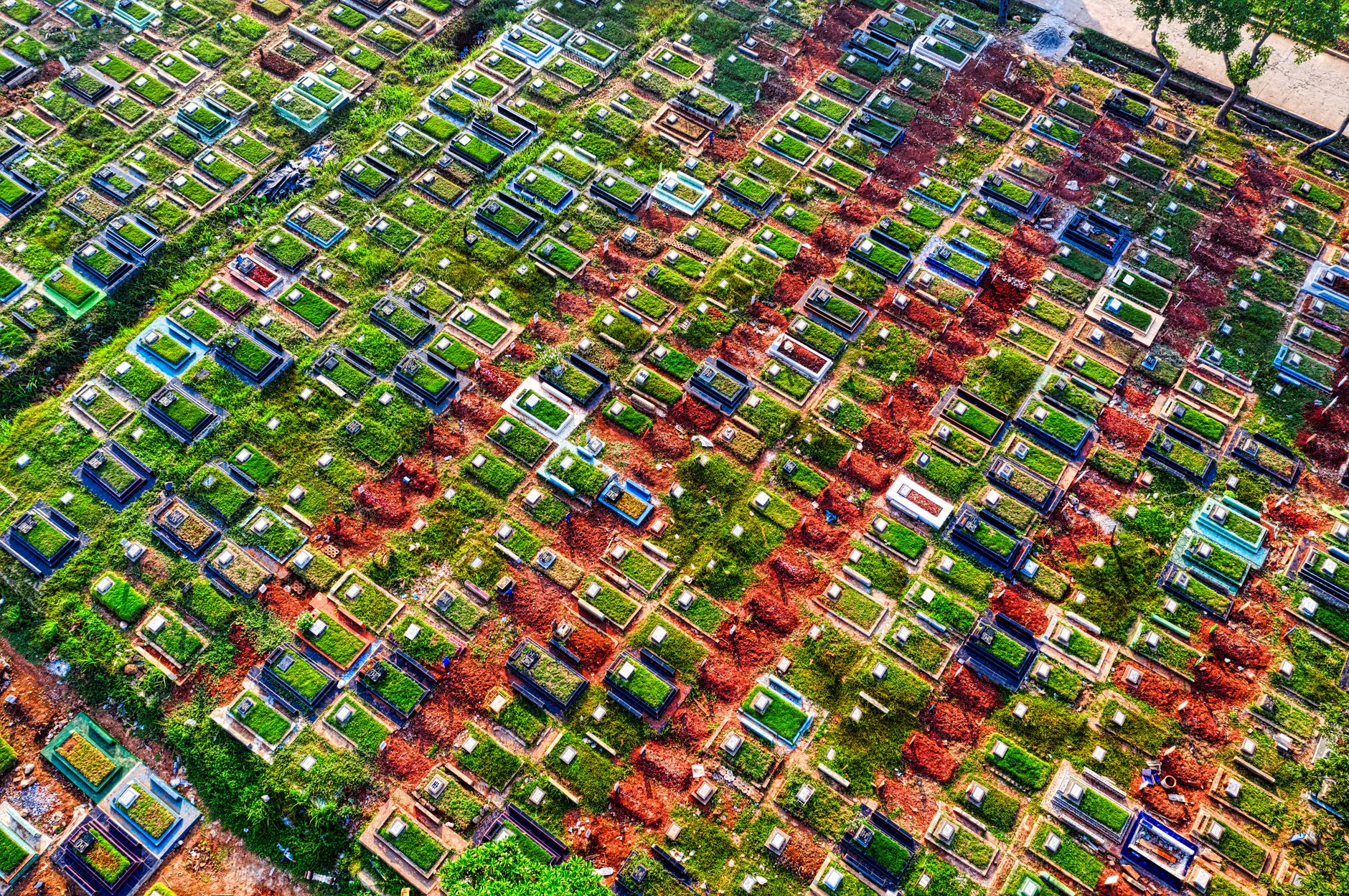 Aerial view of lush cemetery with colorful graves in Jakarta, Indonesia.