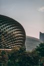 Facade of eye catching geometric Esplanade building with spiked domes located in park in Singapore under blue sky