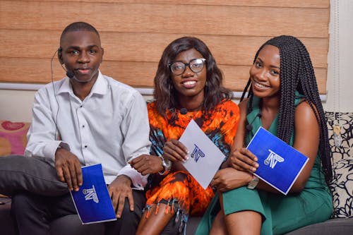 Group of People Holding a Blue and White Paper