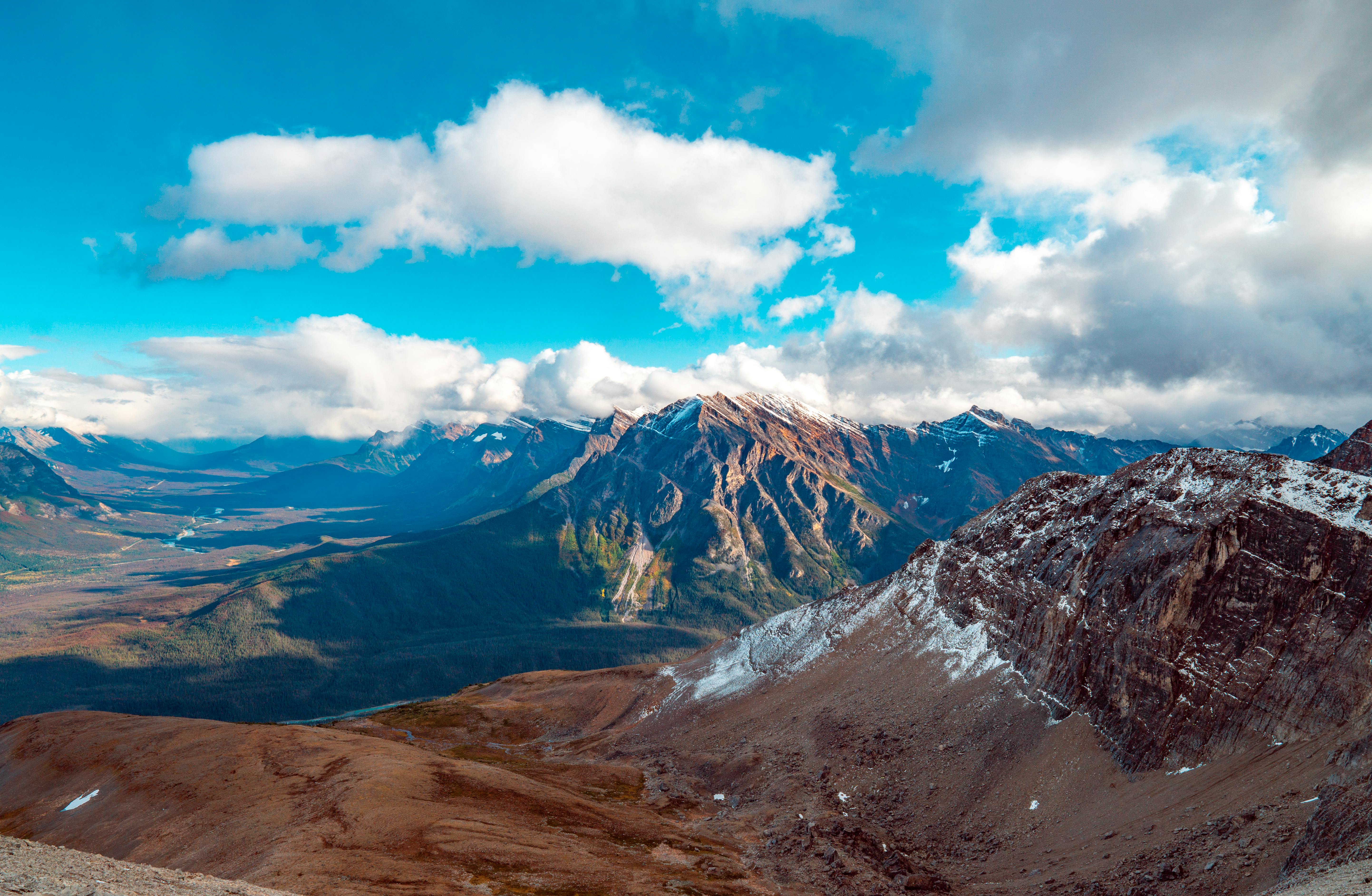 mountains under blue sky and white clouds