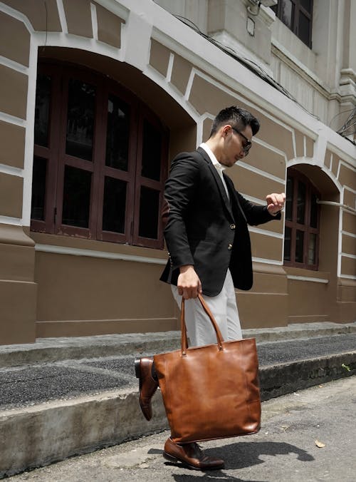 Man in Black Suit Holding Brown Leather Handbag
