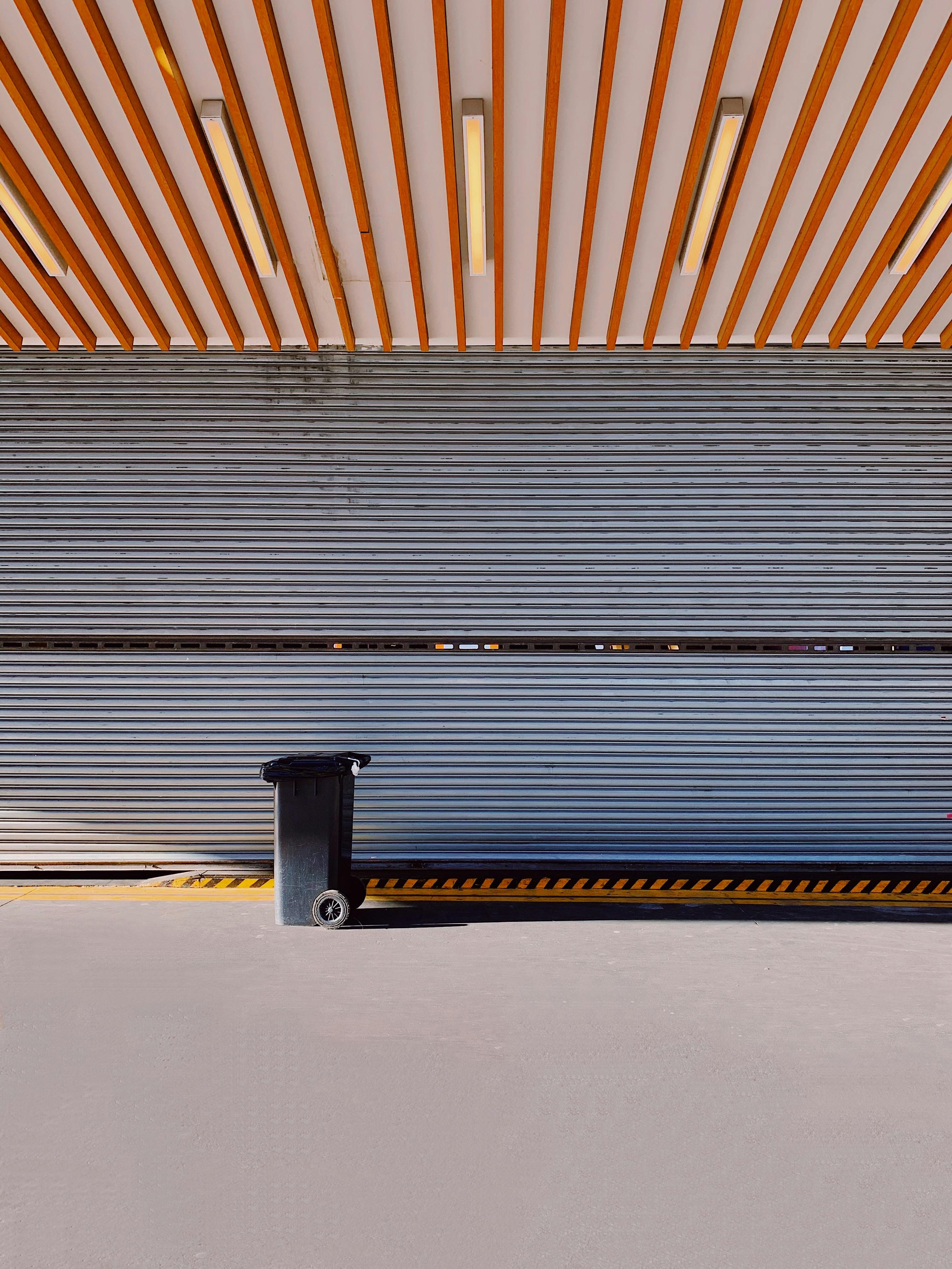 Exterior of contemporary building with geometric elements on roof and metal panels on wall in sunlight