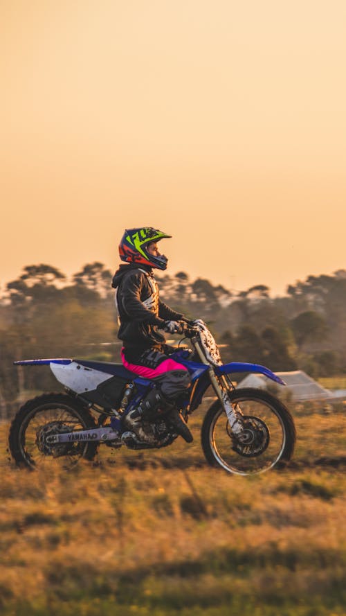 Man in Black Jacket Riding Blue and Black Motocross Dirt Bike