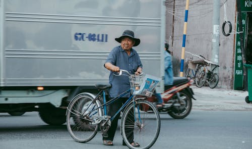 Man in Blue Polo Shirt and Black Hat Riding on Bicycle