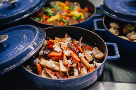 Colorful roasted vegetables in blue cookware, ready to serve.