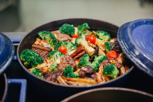 Vibrant dish of broccoli, beef, and veggies in a blue pan, perfect for dinner or lunch.