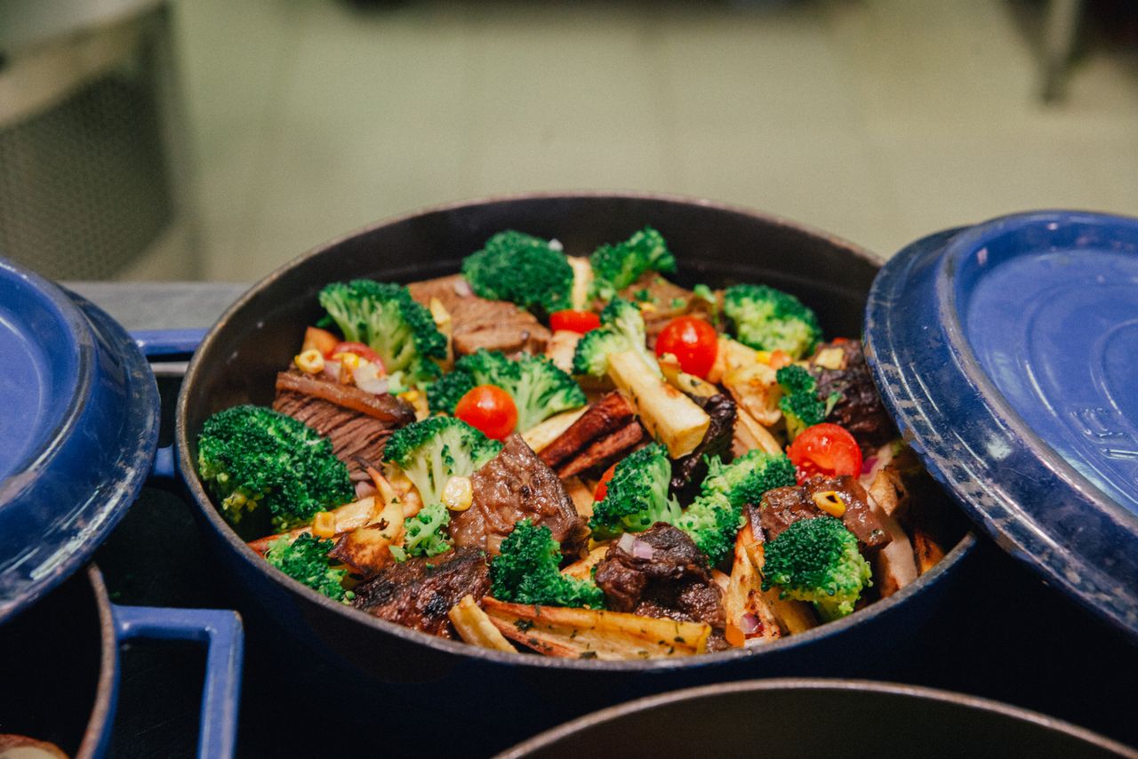 Braised meat and root vegetables in a covered casserole pot, slow-cooked