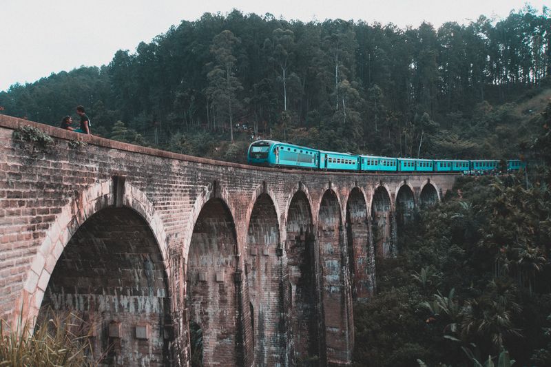 Tren azul cruzando el puente de los Nueve Arcos en Ella, Sri Lanka