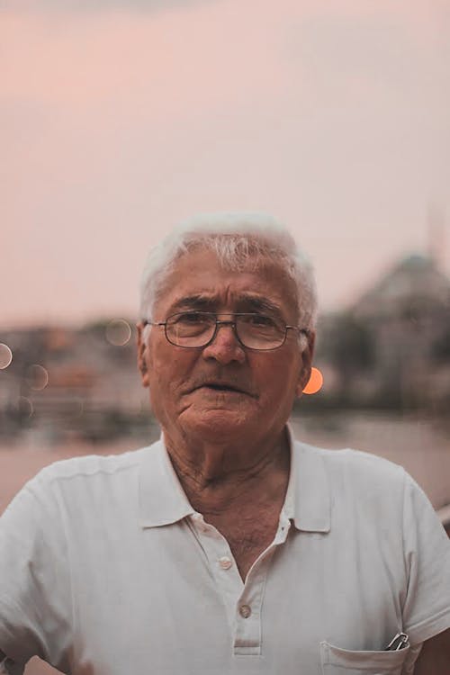 Free Close-Up Shot of an Elderly Man in White Polo Shirt and with Eyeglasses Stock Photo
