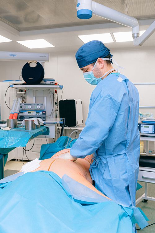 Free Surgeon in surgical attire performing operation in a modern operating room. Stock Photo
