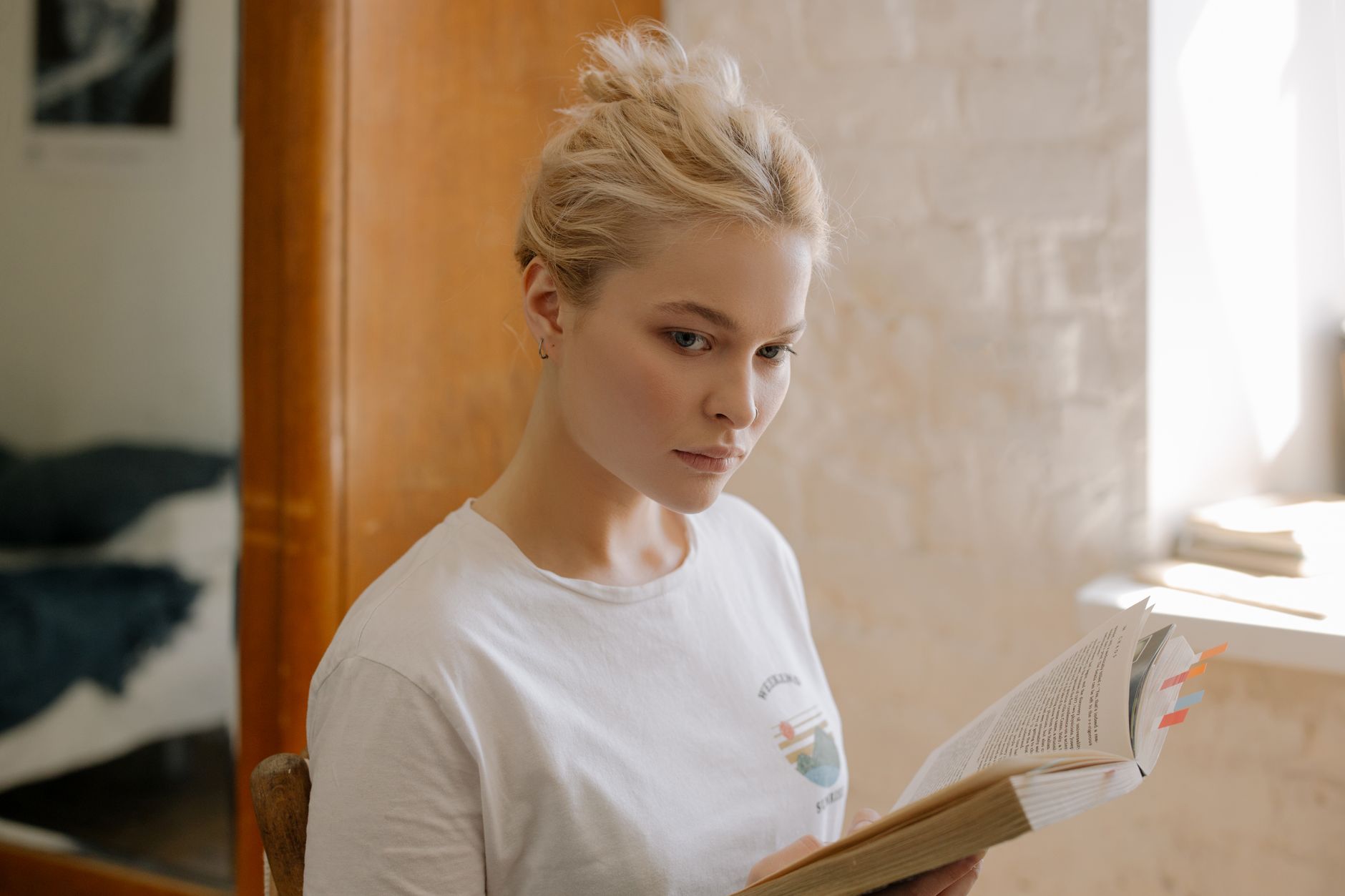 Girl in White Crew Neck Shirt Sitting on Brown Wooden Chair