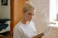 灯光柔和的房间里，一位年轻女子正专注而放松地看着书