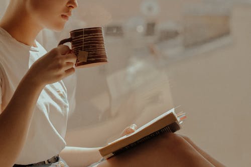 Free Woman in White Shirt Reading Book Stock Photo