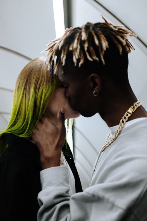 Free Modern couple embraces in urban subway setting, showcasing unique hairstyles and affection. Stock Photo