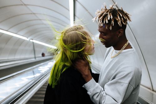 Free Young couple shares an intimate moment on an underground escalator, capturing urban love. Stock Photo