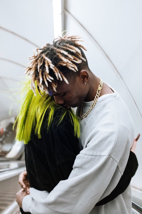 Free A young couple shares a tender hug on an urban subway escalator, expressing romance. Stock Photo