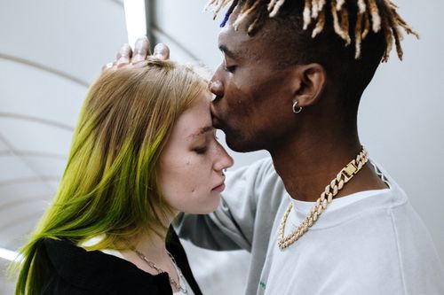 Free A modern couple shares an intimate moment in an urban subway setting. Stock Photo