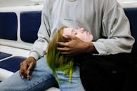 一对风格独特的年轻夫妇在地铁上休息，展现了城市的生活方式