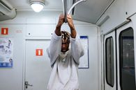 Man in White Robe Holding on Stainless Steel Bar