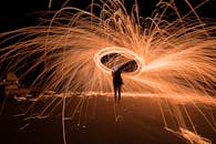 Man in Black Jacket Standing on Fire during Nighttime