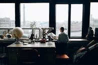 在一间装饰创意十足的书房里，小男孩凝视着窗外，书房采用复古装饰和城市景观