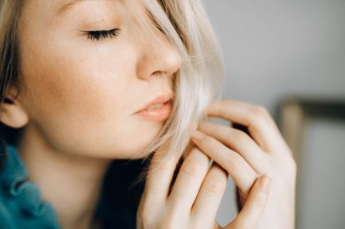 Free A close-up portrait of a serene woman with closed eyes and soft lighting, highlighting her delicate features. Stock Photo