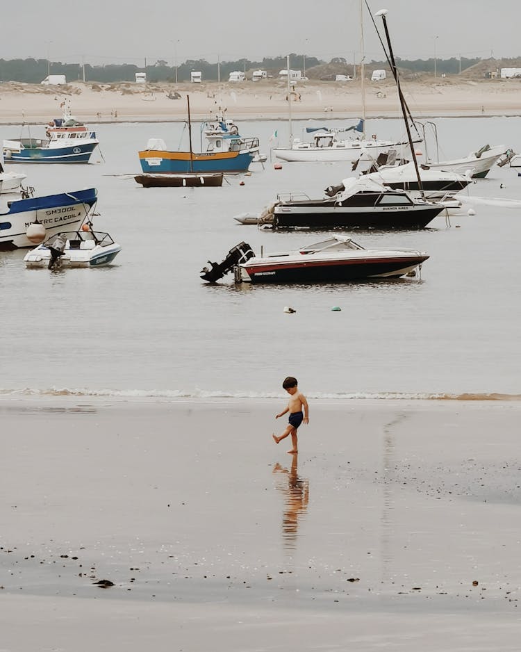 Boy Walking Alone On The Beach