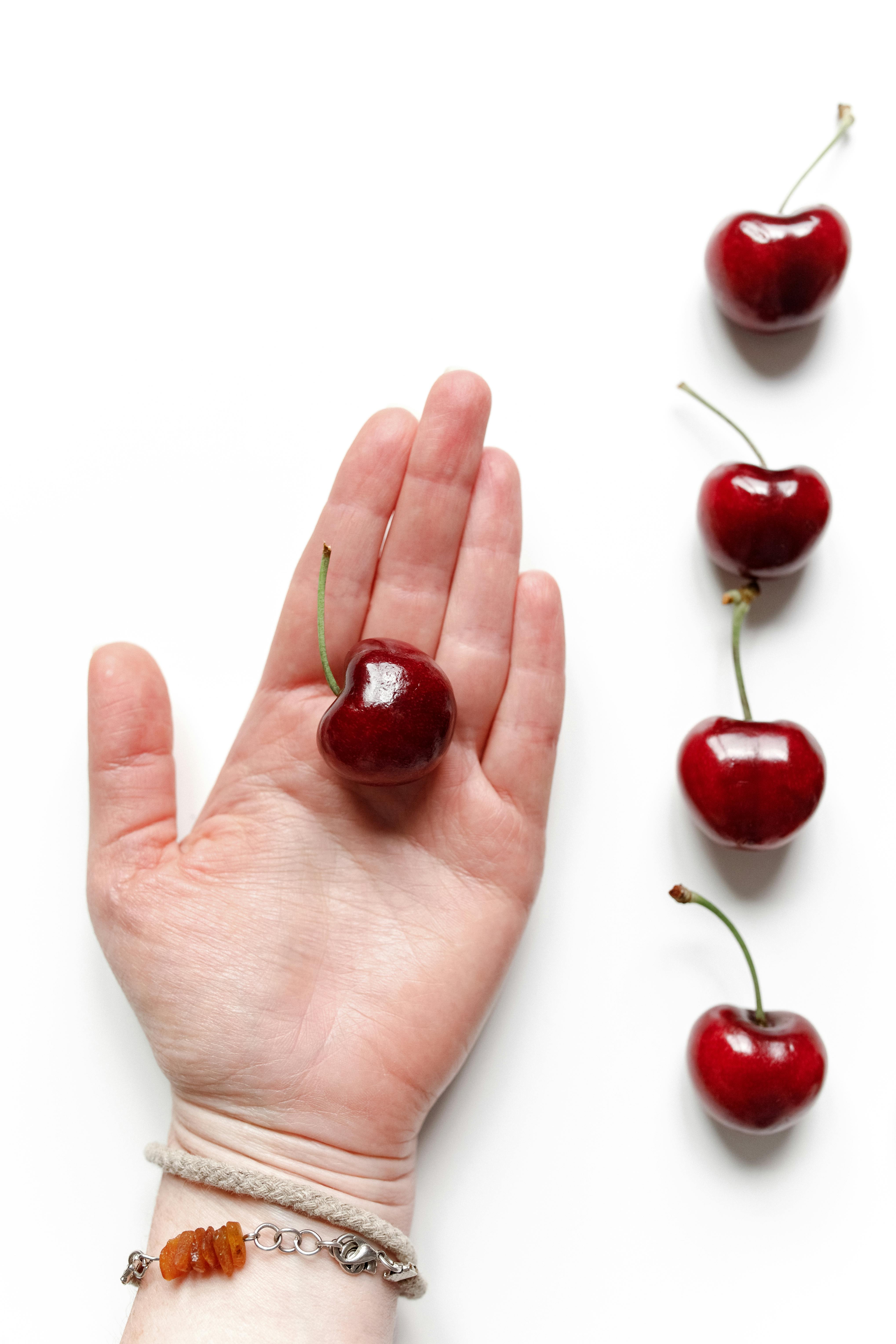 red cherry on person s hand