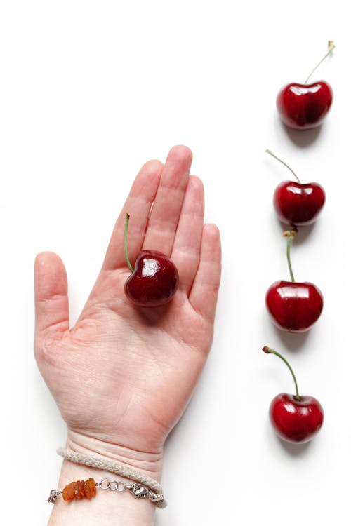 Red Cherry on Person's Hand