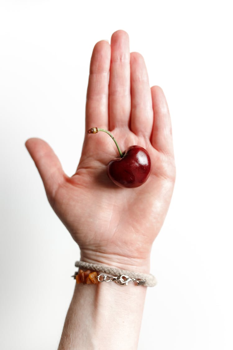 Hand Holding Red Cherry