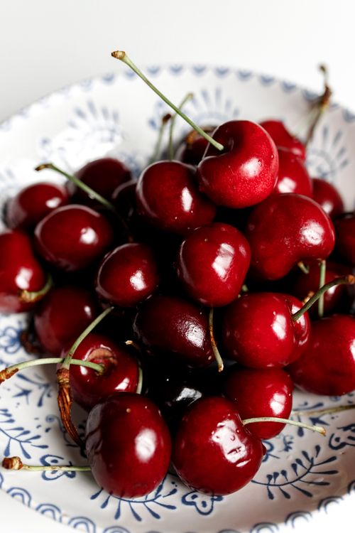 Free Close-up of fresh ripe cherries in a decorative ceramic plate, showcasing vibrant color. Stock Photo