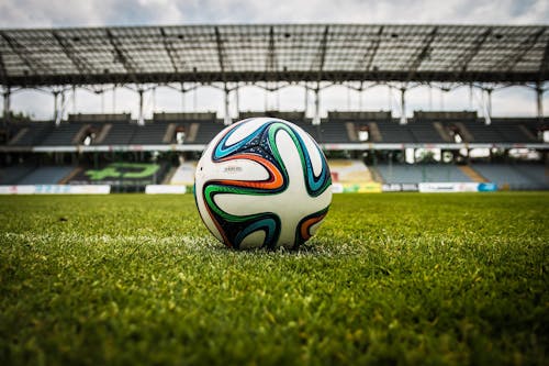 Multicolored Soccer Ball on Green Field