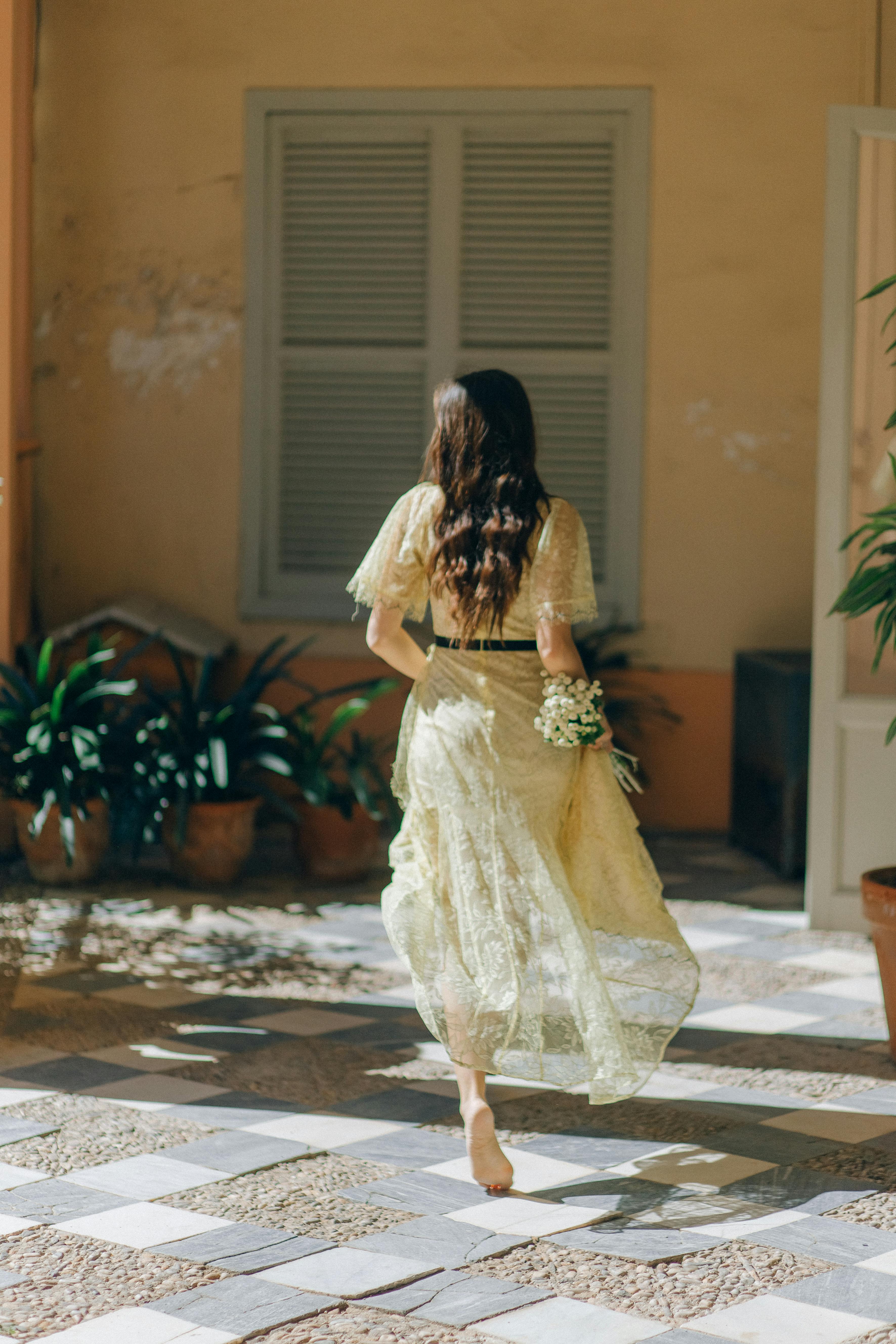 back view photography of a woman in beige lace dress