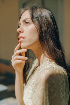 阳光下，一位美丽的女人穿着蕾丝连衣裙，在户外优雅地摆姿势
