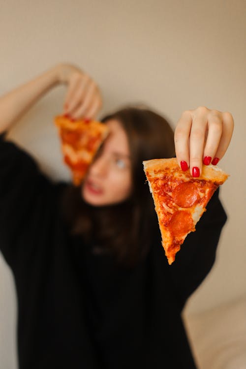 Free Woman in Black Long Sleeve Shirt Holding Sliced Pizza Stock Photo