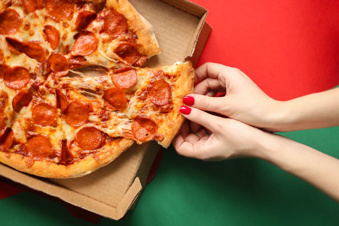 Free Person Holding Brown and Red Pizza Stock Photo