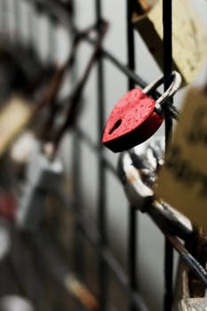 特写镜头：金属栅栏上附着的红色心形挂锁