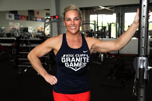 Athletic woman in a gym smiling confidently, showcasing strength and fitness.